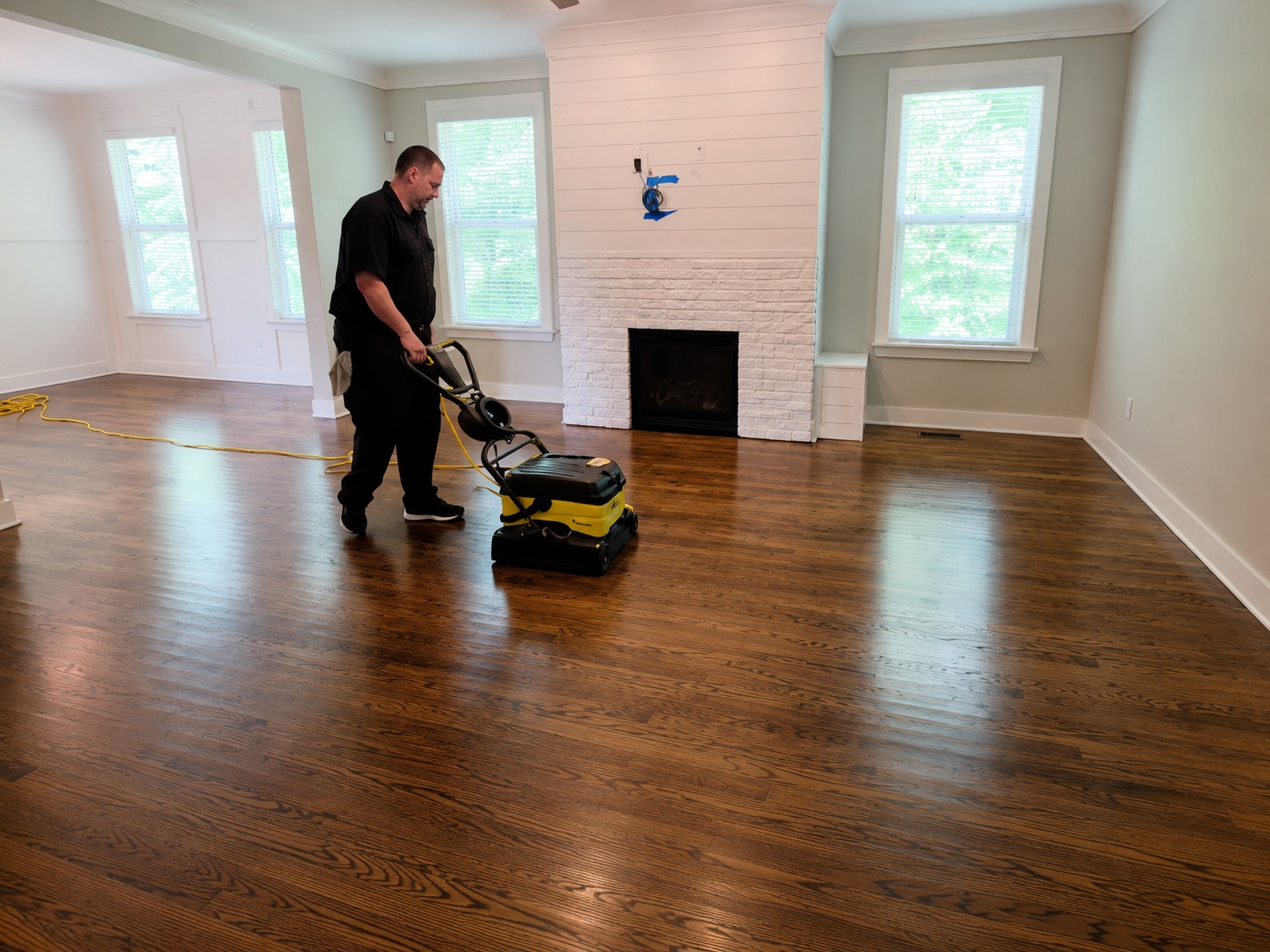 True Clean professionally cleaning hardwood floors with yellow floor cleaning equipment in Durham North Carolina