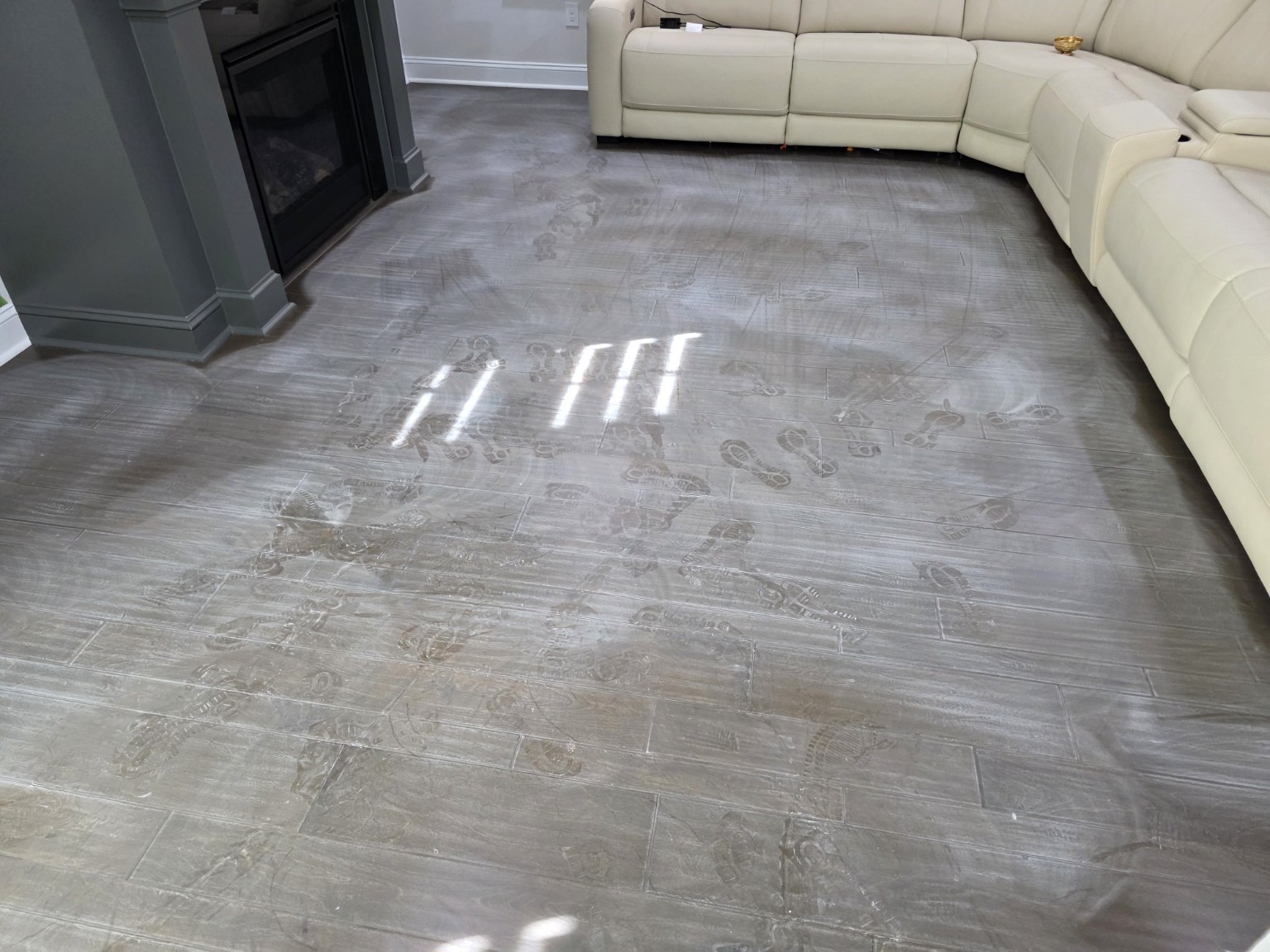 Engineered hardwood floor before screen and recoat with visible footprints and wear