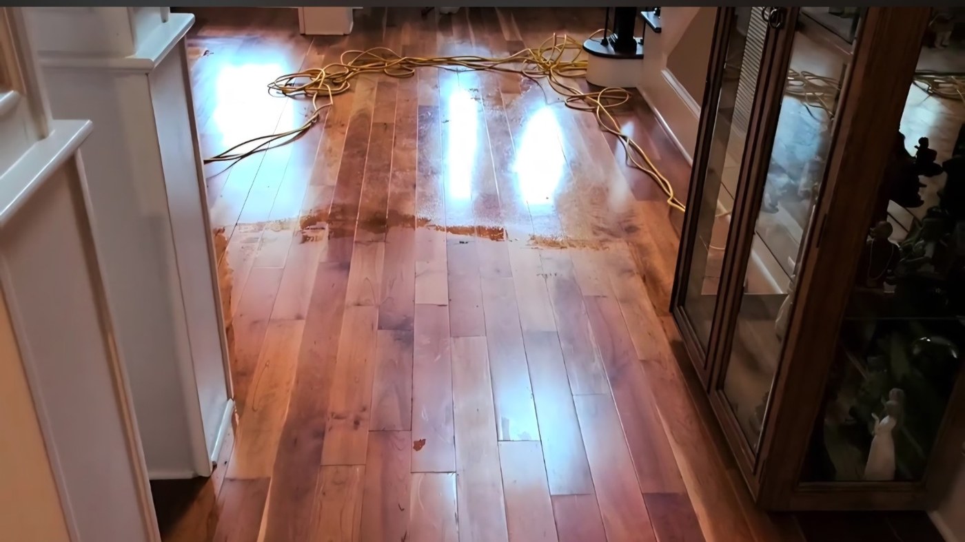 Hardwood floor with coating buildup and partial removal visible