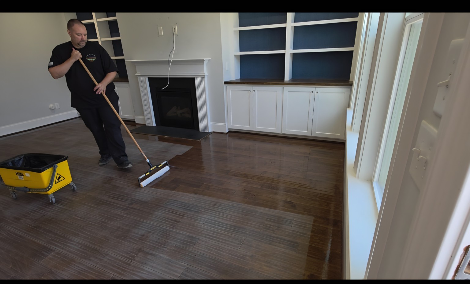 Robert applying finish section by section to a hardwood floor