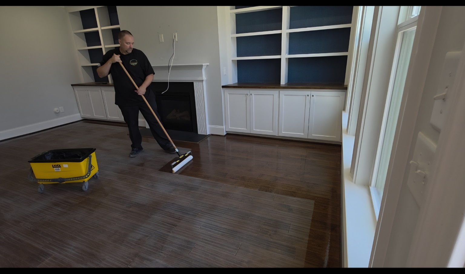 Robert applying hardwood floor finish with a professional applicator