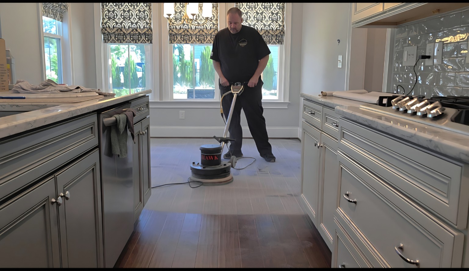 Robert buffing a hardwood floor in a kitchen