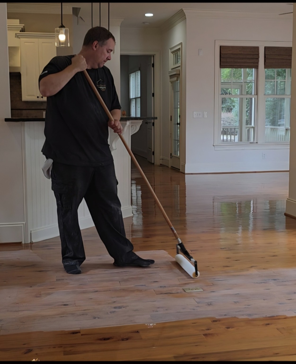 Robert applying polyurethane finish to a hardwood floor